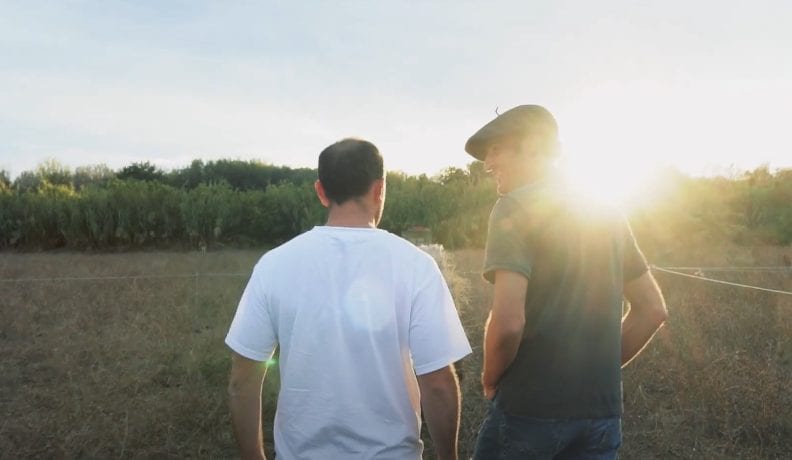 a couple of men standing next to each other in a field.