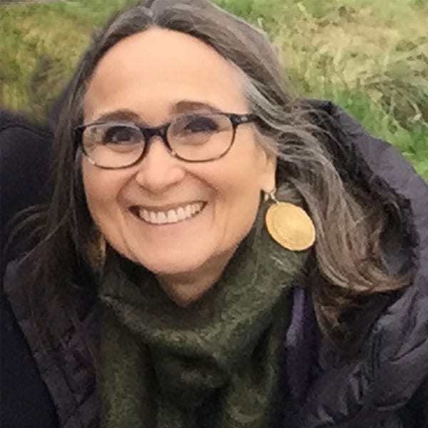 a woman wearing glasses and a green scarf.