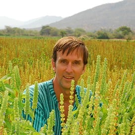 a man standing in a field of tall grass.