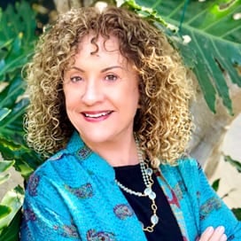 a woman with curly hair wearing a blue jacket.