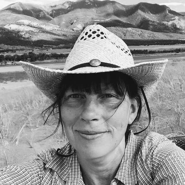 a woman wearing a cowboy hat in a field.