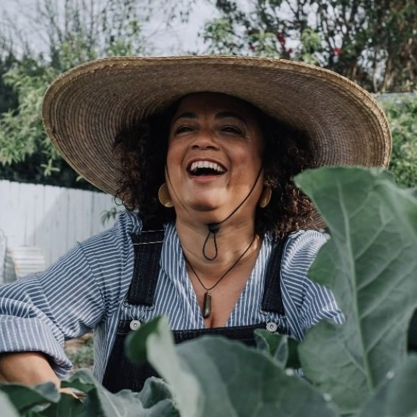 a woman wearing a straw hat in a garden.