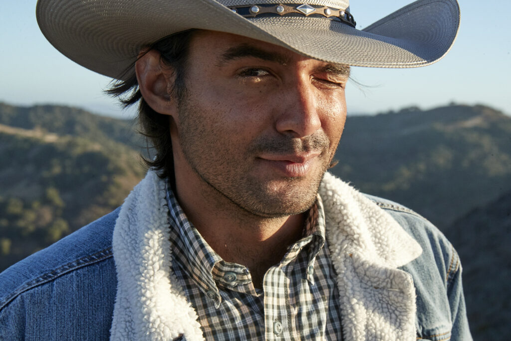 a man wearing a cowboy hat and a plaid shirt.